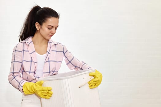 Woman is holding basket with laundry, copy space