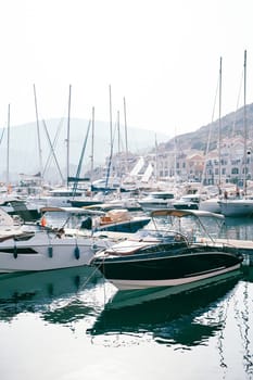 Piers with moored yachts near the shore with colorful buildings. Lustica Bay Marina, Montenegro. High quality photo