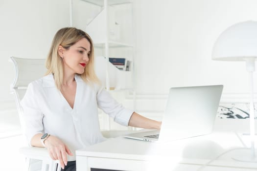 Business woman in office at laptop small business online. High quality photo