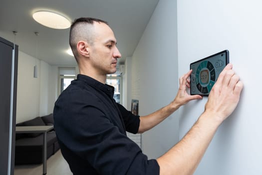 automation, internet of things and technology concept - man looking at tablet pc computer at smart home. High quality photo