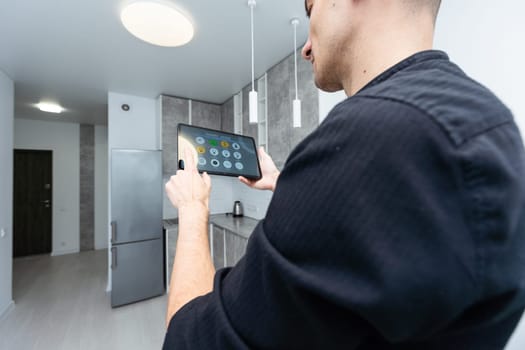 Worker with tablet computer checking alarm system indoors. High quality photo