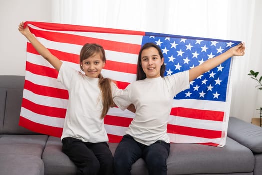 Two sisters with American flag on grey background. High quality photo