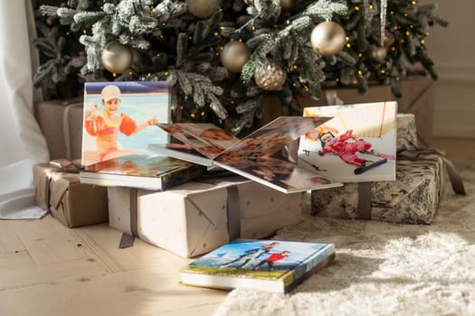 Photo book album under the Christmas tree surrounded by Christmas gifts. High quality photo