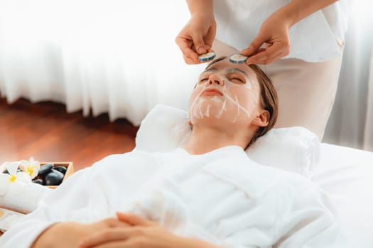 Serene daylight ambiance of spa salon, woman customer indulges in rejuvenating with luxurious cucumber facial mask. Facial skincare treatment and beauty care concept. Quiescent