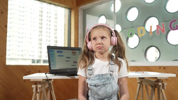 Caucasian tired girl bored while laptop screen display engineering prompt programing code. Pretty smart student with headphone asking or talking about science technology in STEM education. Erudition.