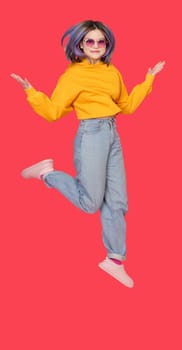 Smiling Asian girl teenager in mid-jump against vibrant red color background. Exuberance and happiness of youth, showcasing dynamic and lively nature of teenager in moment of pure joy and positivity. High quality photo