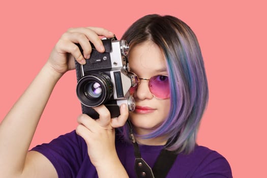 Teenager asian girl with old school photo camera against vibrant pink background. Youthful enthusiasm for photography, combining modern era with vintage charm of analog camera. close-up portrait. High quality photo