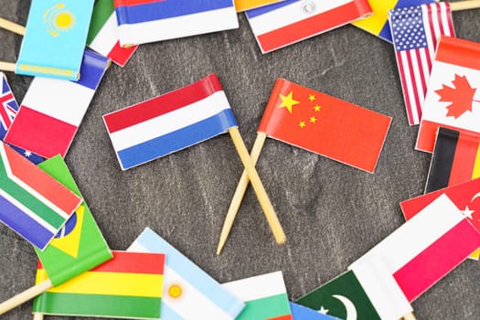 Policy. National flags of different countries. The concept is diplomacy. In the middle among the various flags are two flags - China, Netherlands