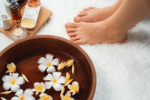 Couple indulges in blissful foot massage at luxurious spa salon for reflexology therapy in gentle day light ambiance resort or hotel foot spa. Quiescent