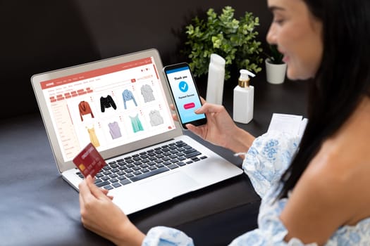 Young woman order or purchase product on internet using laptop and make transaction payment by smartphone. Online shopping lifestyle with credit card via internet banking on mobile application. Blithe