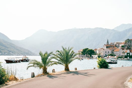 Sunny embankment of Perast with boats moored off the coast. Montenegro. High quality photo