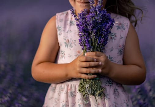 girl lavender field in a pink dress holds a bouquet of lavender on a lilac field. Aromatherapy concept, lavender oil, photo shoot in lavender.