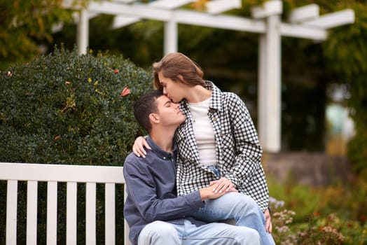 lovely young couple kissing outdoors in autumn. Loving couple walking in nature. Autumn mood. Happy man and woman hugging and kissing in autumn. Love. Fashionable couple outdoors. Fashion, people and lifestyle. Stylish couple in autumn outfit.