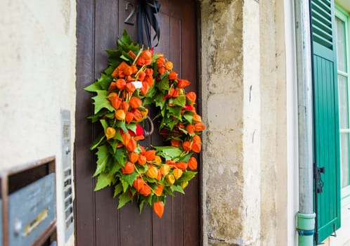 Autumnal wreath with Physalis on a wood door