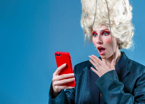 Royal online shopping. Funny princess, queen wearing vintage royal wig with red makeup woman online shopping browses internet and networking in social media tests new application for smartphone.