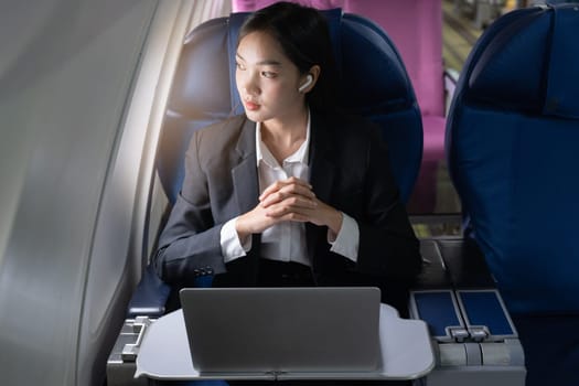 Beautiful Asian businesswoman working with laptop in aeroplane. working, travel, business concept.