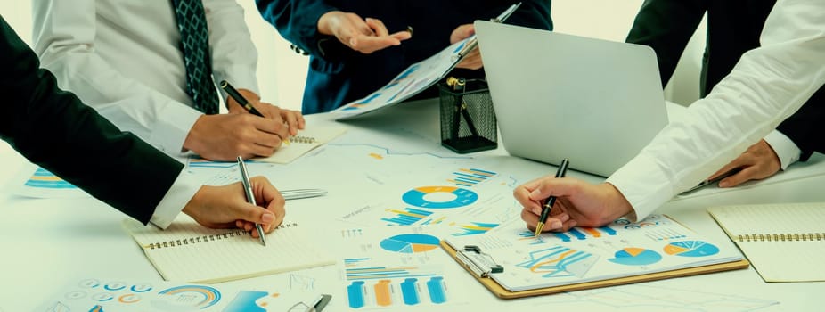 Business people in group meeting in formal attire share idea discussing report for company profit in creative workspace for start up business shot in close up view on group meeting table . Oratory .