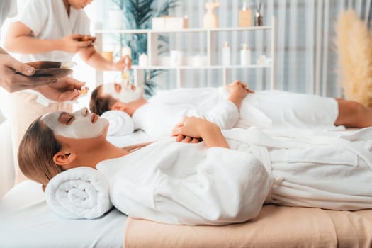 Serene ambiance of spa salon, couple indulges in rejuvenating with luxurious face cream massage with modern daylight. Facial skin treatment and beauty care concept. Quiescent