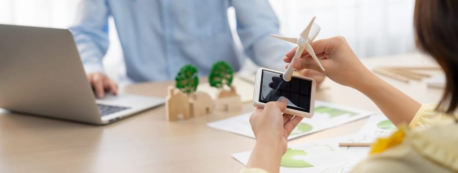 Businesswoman interested in investing in renewable energy at meeting table with environmental document scatter around. Business team discussion about green business project. Closeup. Delineation.