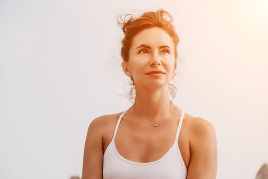 Fitness woman sea. Outdoor workout on yoga mat in park near to ocean beach. Female fitness pilates yoga routine concept. Healthy lifestyle. Happy fit woman exercising with rubber band in park.