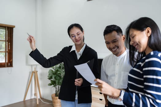 young couple with a real estate agent visiting home for buy or for rent.