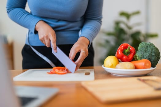 Fat woman cook in kitchen and chopping fresh vegetable on chopping board. health care concept Eat healthy food to lose weight.