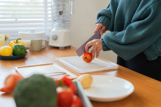 Fat woman cook in kitchen and chopping fresh vegetable on chopping board. health care concept Eat healthy food to lose weight.