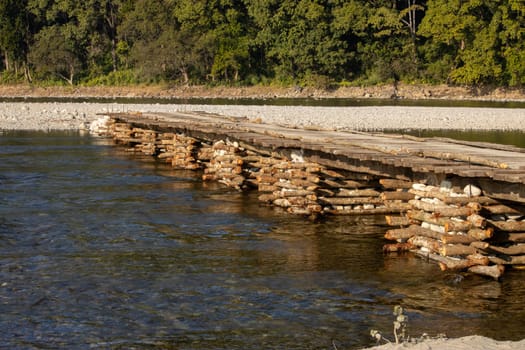 Gracefully suspended over the river, the beauty of a wooden bridge in Uttarakhand .High quality image