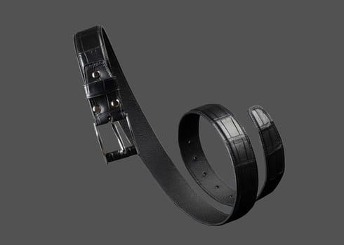 Black leather belt twisted in a spiral on a gray background.