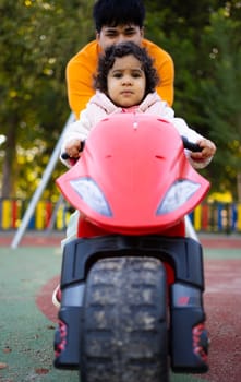 Close up low angle view of father and daughter enjoying time together riding a toy.