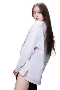 Beautiful Slavic girl with long hair in an ethnic shirt on a white background.