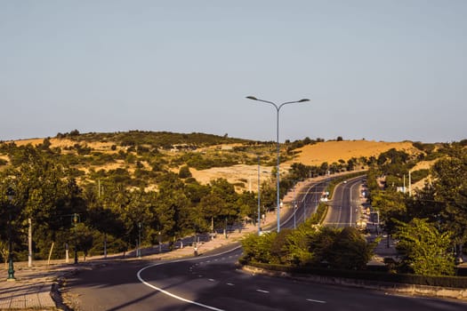 Highway curve road overpass nature landscape background dark tone mist day time street tall lanterns trees bushes sideway.