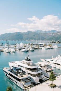 Motor yachts moored near the pier against the background of mountains. High quality photo