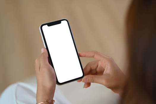 Closeup young woman holding mobile phone with white empty screen for application advertising.