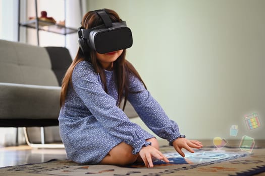 Child girl wearing VR headset and exploring virtual reality. Future technology concept