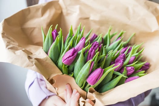 Colorful tulips on craft paper.Yellow, pink, magenta or fuchsia tulips on brown wrapping paper. Muted tone. Spring holiday floral decor.