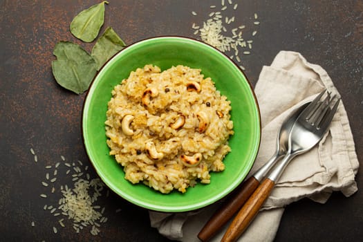 Ven Pongal (Khara Pongal), traditional Indian savoury rice dish made during celebrating Pongal festival, served in bowl top view on concrete rustic background.