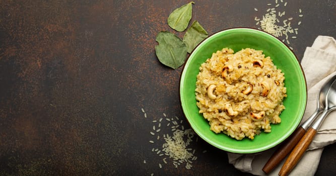 Ven Pongal (Khara Pongal), traditional Indian savoury rice dish made during celebrating Pongal festival, served in bowl top view on concrete rustic background, space for text.