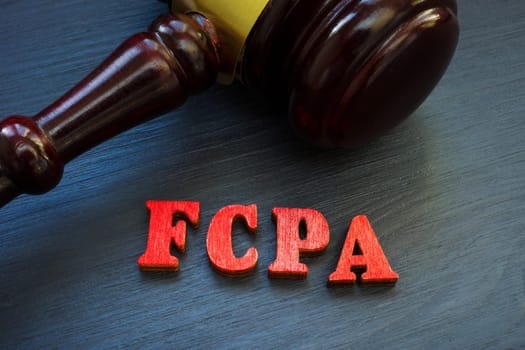 Gavel and letters FCPA Foreign Corrupt Practices Act on wooden surface.