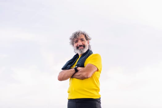 senior sports man posing happy with arms crossed looking at camera, concept of active and healthy lifestyle in the middle age, copy space for text