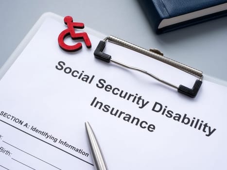Clipboard with Social Security Disability Insurance SSDI policy.