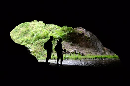 Couple of tourists at the entrance of a cave
