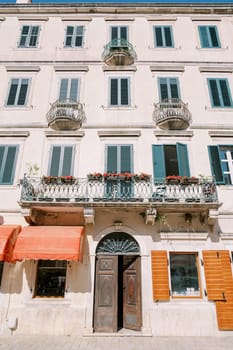 Facade of an old house with a terrace above the entrance and small balconies. High quality photo