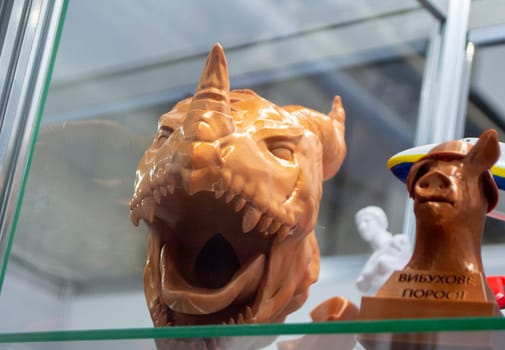 Prototype of art object 3D printed from melted brown plastic. Model of animal head with teeth and horn created 3D printer. New innovation modern 3D printing technology. Additive progressive technology