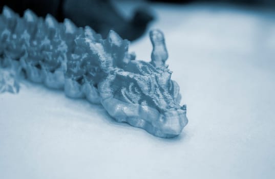 Prototype of blue dragon 3D printed from melted plastic. Close-up model of toy created on 3D printer. New innovation modern 3D printing technologies. Additive progressive technology. 3D model