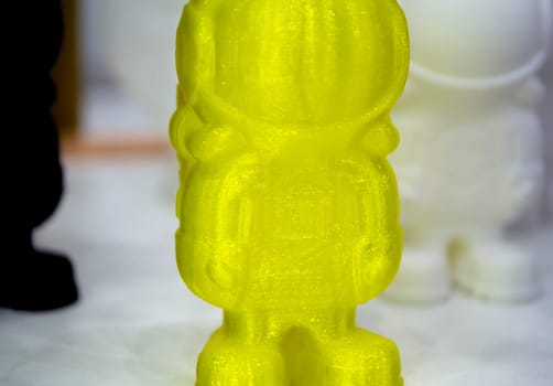 Object model printed on a 3D printer from yellow molten plastic. 3D printer printed prototype of toy from plastic. 3D design and prototyping. Additive progressive new modern 3d printing technology