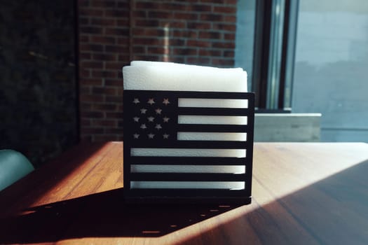 napkin holder in a cafe on a table in the form of an American flag. High quality photo