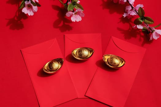 Chinese New Year Spring festival decorations red packet and gold ingots on red background. Chinese translation : good fortune, good luck, wealth, and money flow.