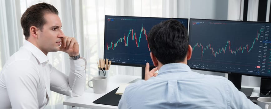 Stock exchange traders discussing on market stock comparing with two screen in chart on panorama view, analyzing on monitor. Concept of financial technology crisis situation at workplace. Sellable.