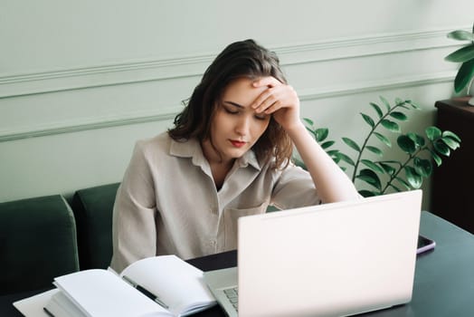 Overworked and Stressed. Young Woman Napping at Laptop, Lost in Thoughts. Exhausted and Stressed. Young Woman Contemplating at Laptop, Overwhelmed by Overwork and Fatigue.